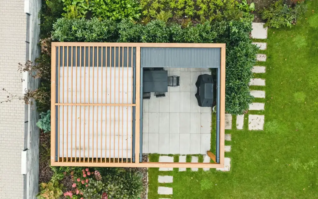 Nowoczesna pergola ogrodowa drewniana na płytach betonowych. Ażurowe zadaszenie.